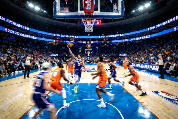 NBA新赛季开幕战现场，两支球队在球场上激烈对抗